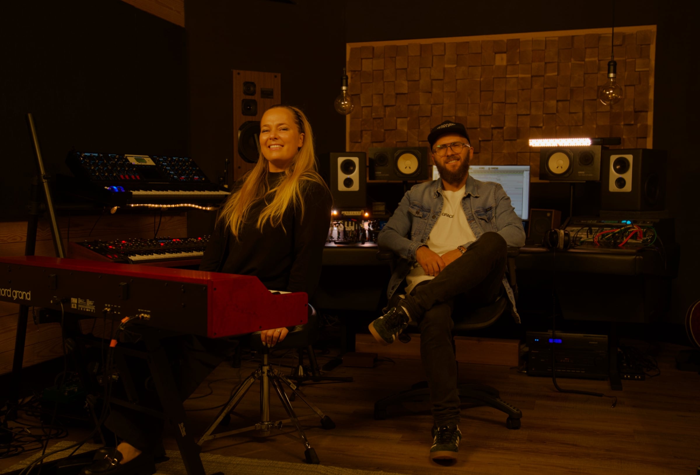 Vasyl and Anna in the Imprint Production control room, surrounded by keys, synths and monitors